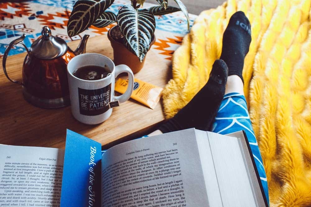 Estudiar inglés libro abierto encima de unas piernas de una persona y un café al lado